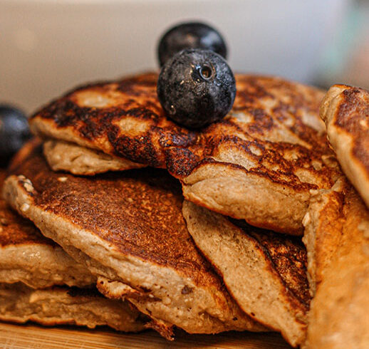 Stack of wheat pancakes with two blueberries on top