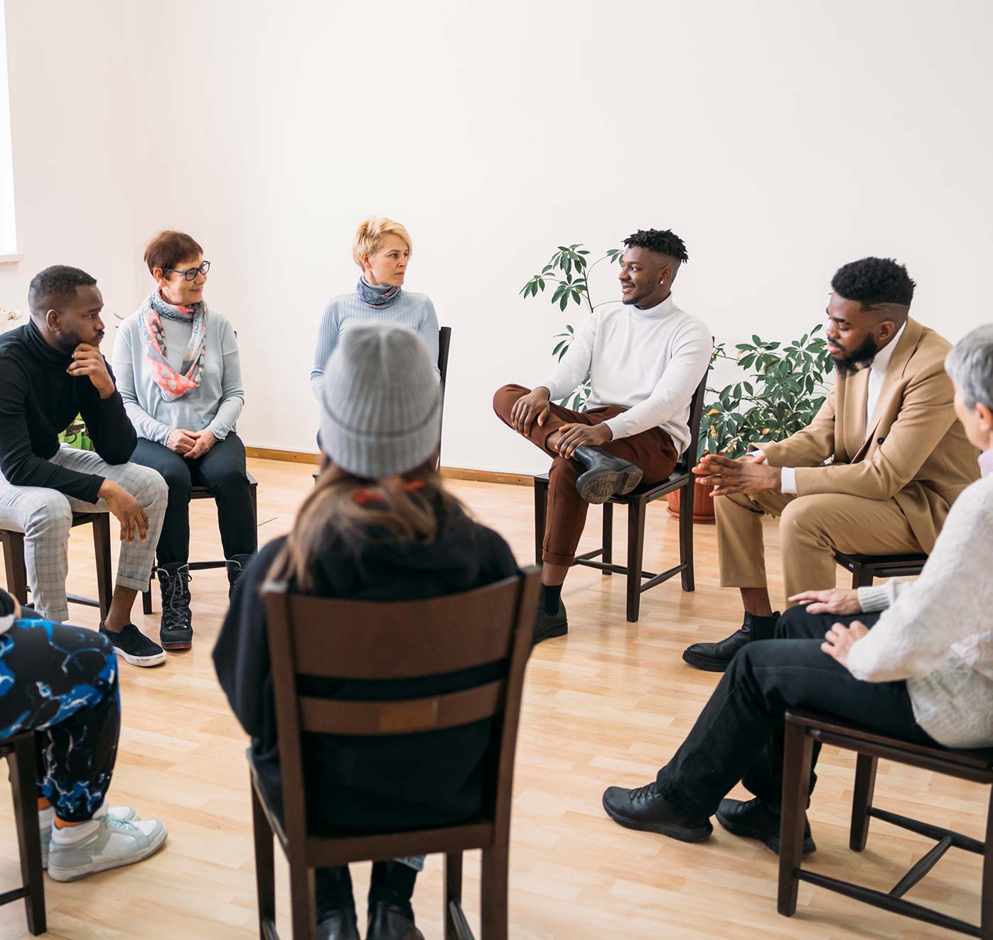 A group of people sitting around a circle having a meeting