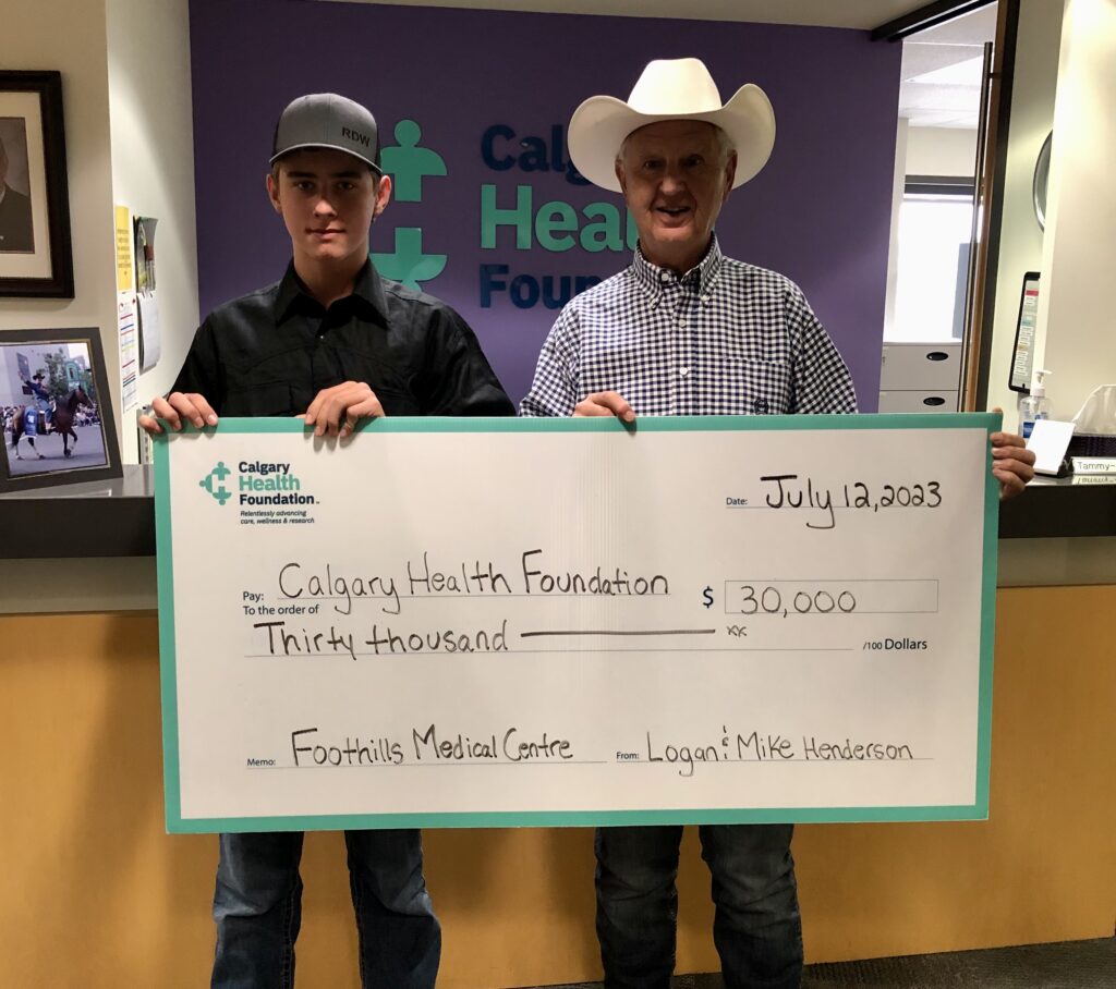 Two men holding up a novelty cheque for $30,000